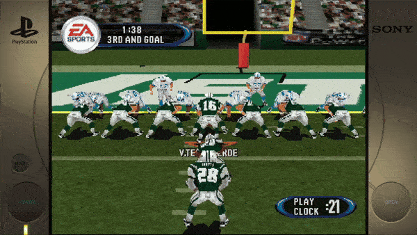 Sure, here's the text extracted from the image: - EA SPORTS - 1:38 - 3RD AND GOAL - PLAY CLOCK - 21 (Additional visible text on player jerseys and the PlayStation console graphics are present.)